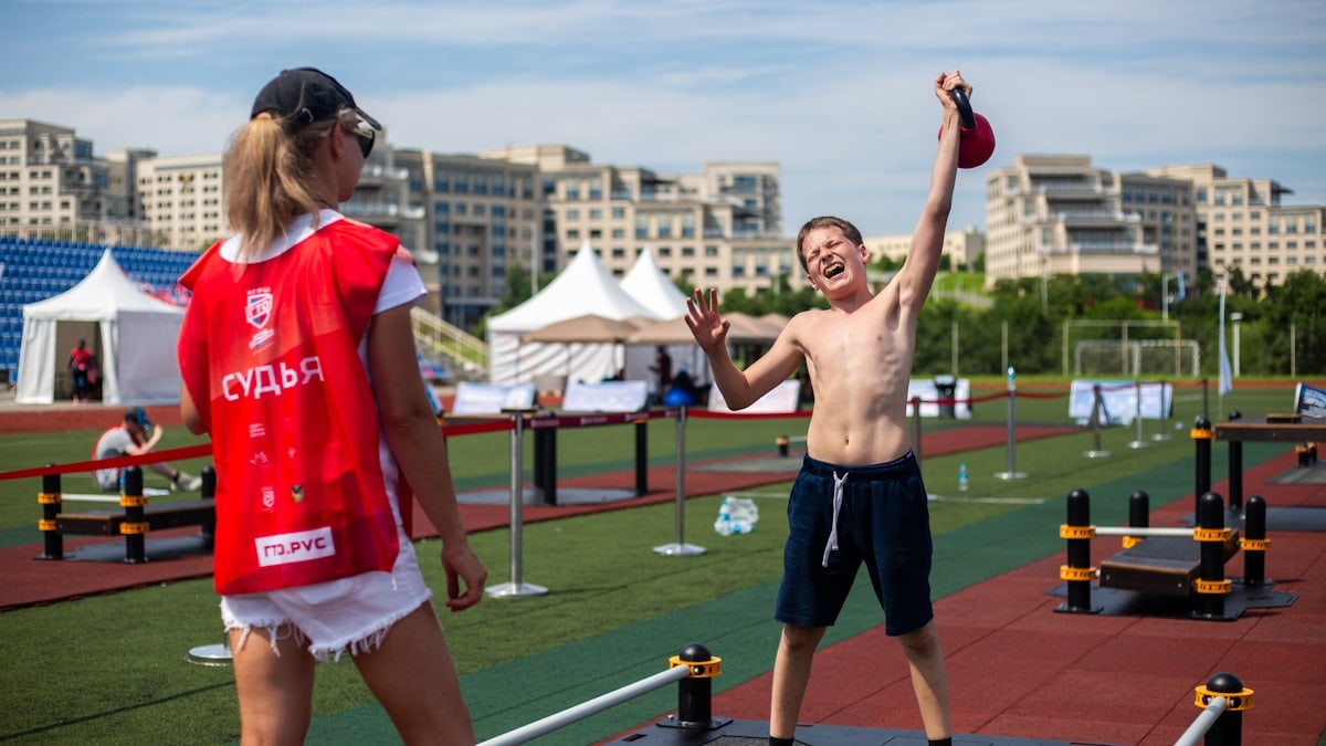 A man holding a red frisbee standing next to a woman