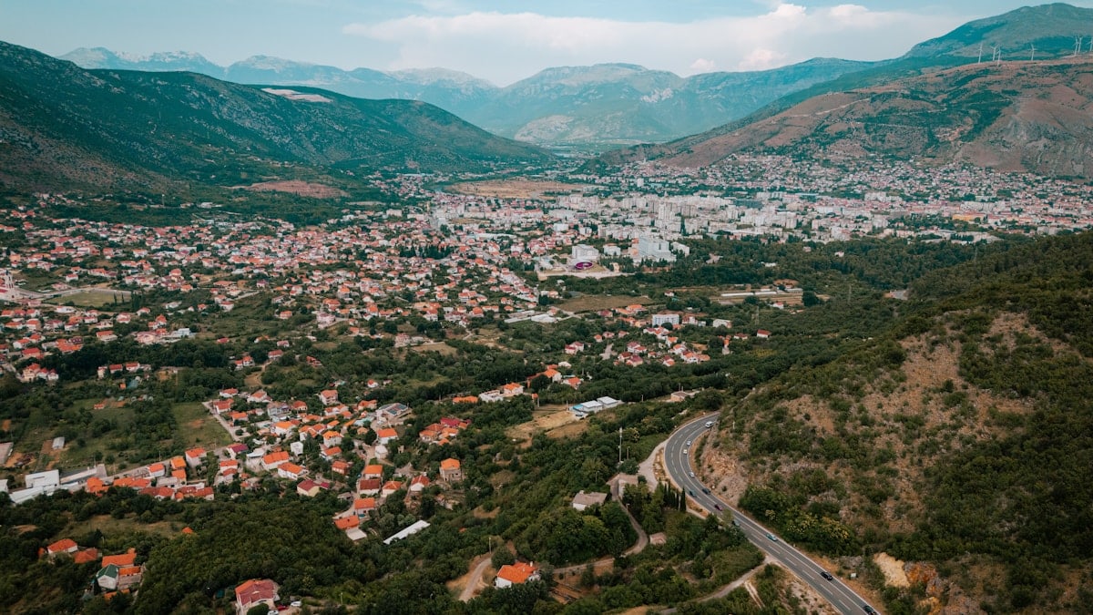 An aerial view of a city with mountains in the background